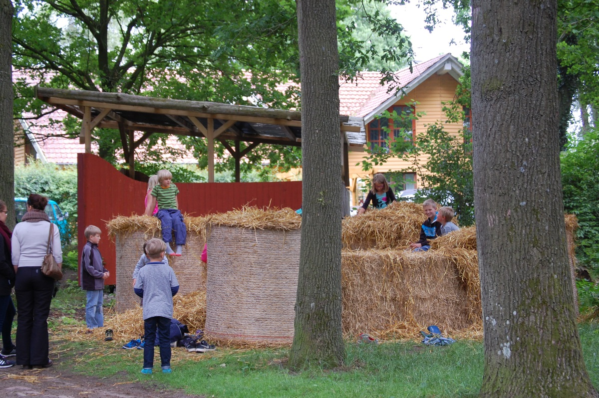 Kinder spielen auf Strohballen während eines Hoffestes