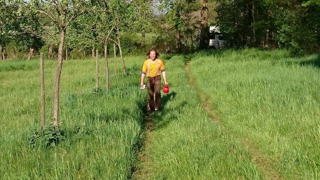 Uli mit Wasserkanne auf der jungen Obstbaumreihe